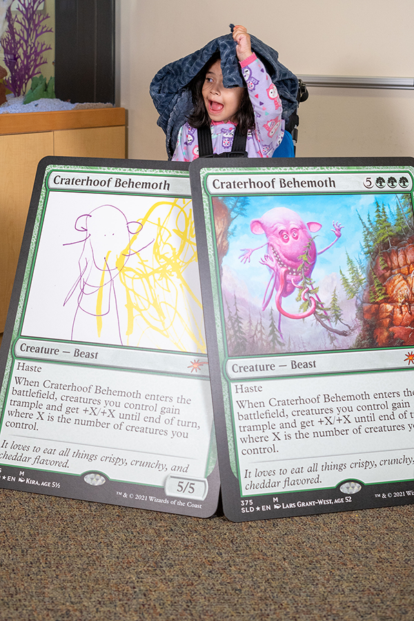 Kira, illustrator of Craterhoof Behemoth, and giant card versions of her creation