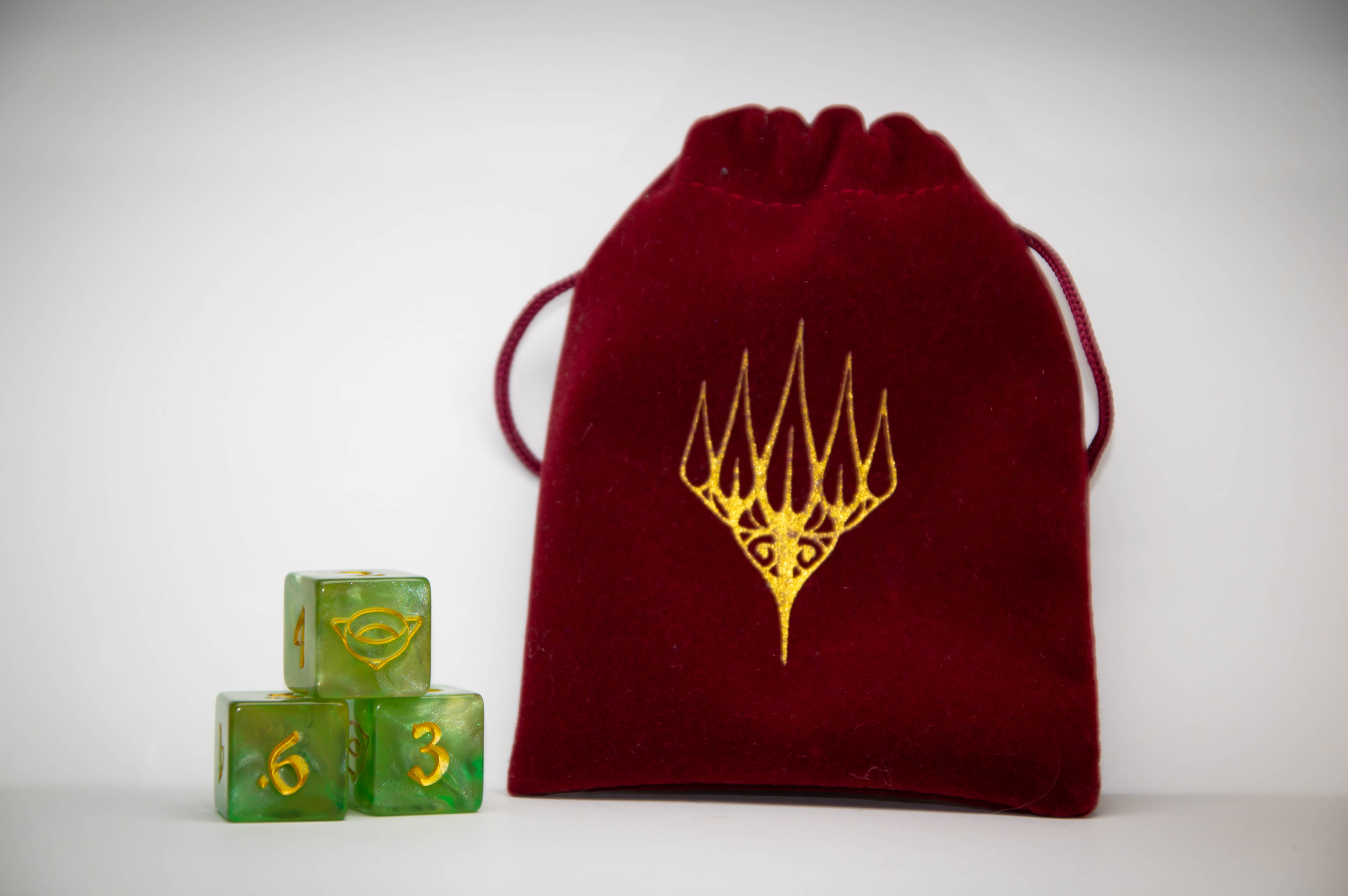 Example set of green dice and burgundy dice bag with gold Planeswalker symbol